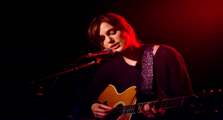 스틸컷- 그레타가 무대에서 기타를 치고 있다.