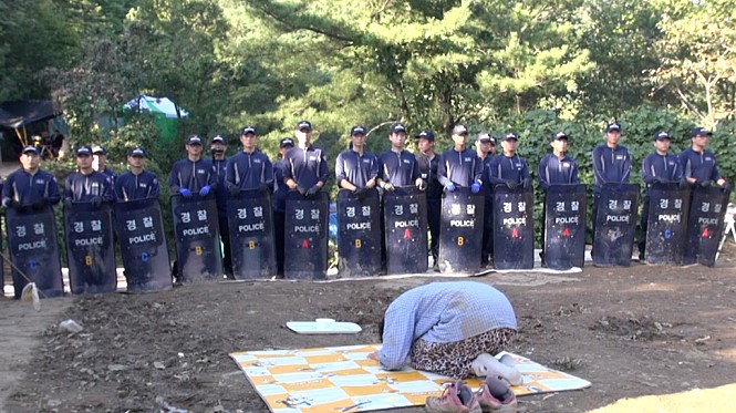 경찰 부대 앞에서 절하는 영자 어무이